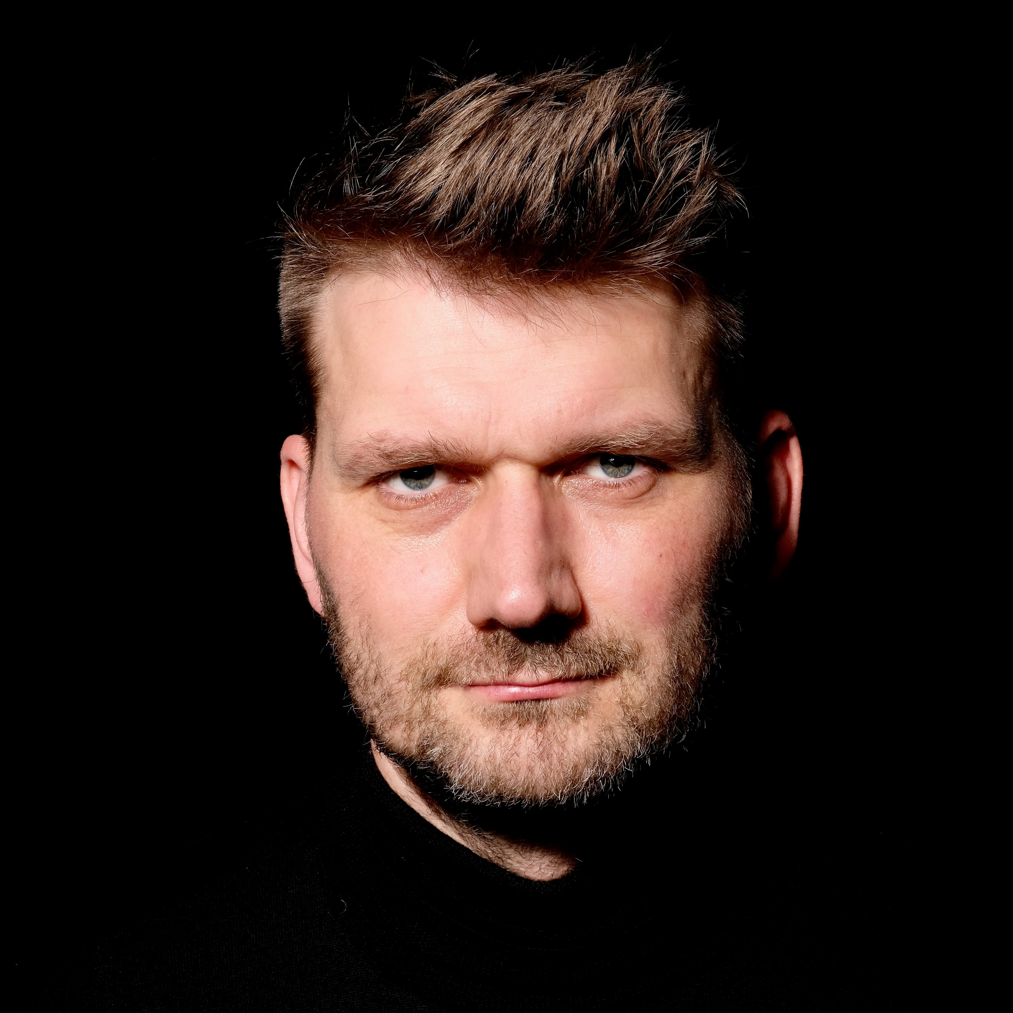 Hendrik Bruns, close colour portrait against a black background.