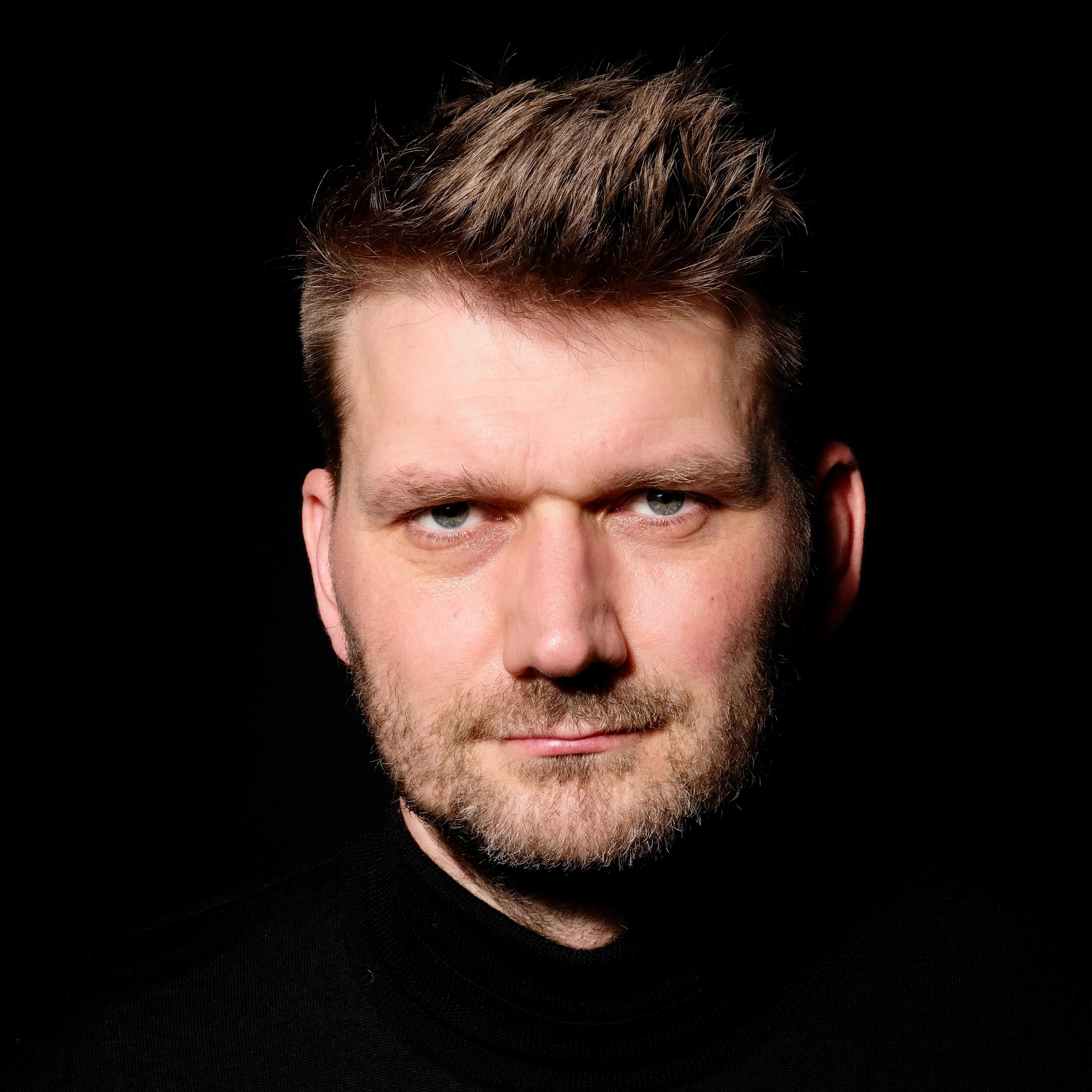 Hendrik Bruns, nahes Porträt vor schwarzem Grund.